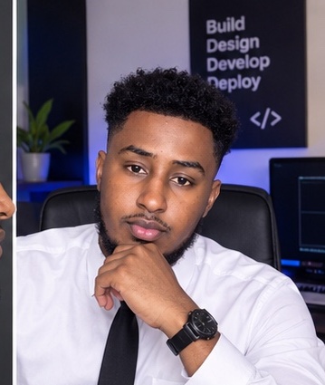 Musharaf seated at his desk in front of a 'Build, Design, Develop, Deploy' poster